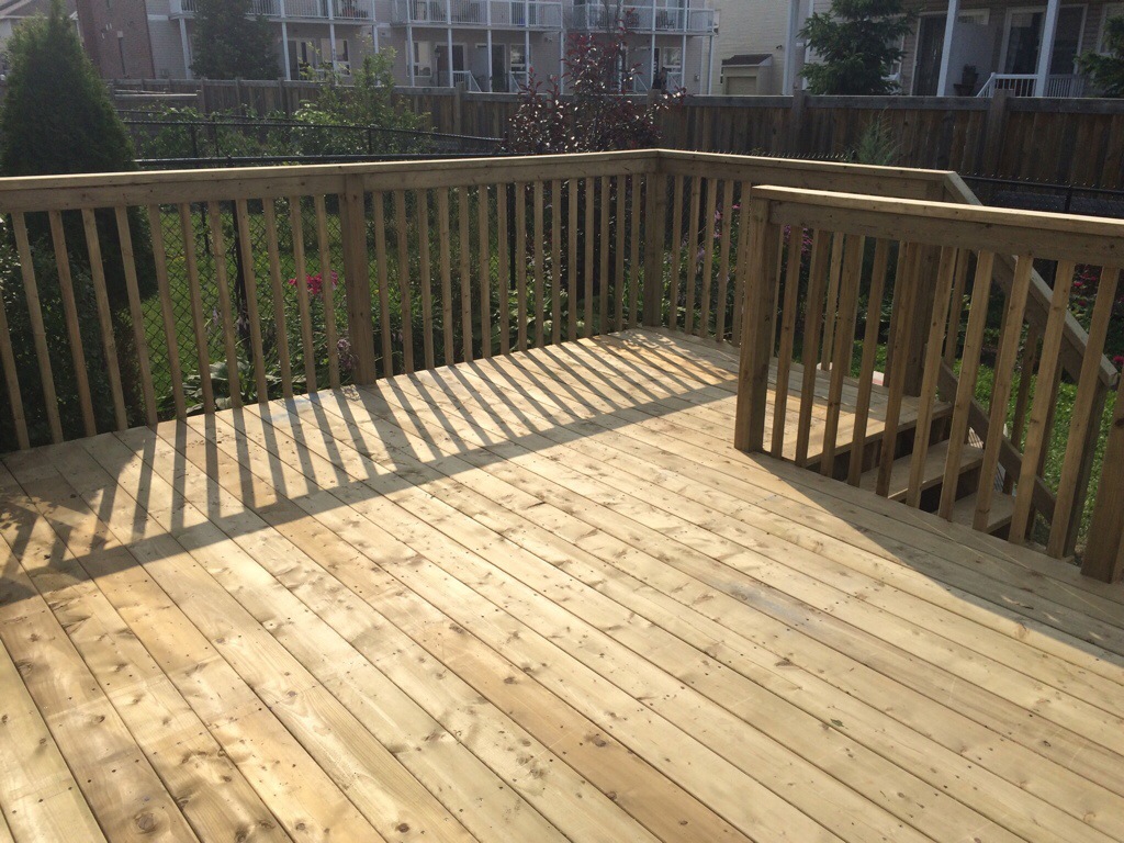 A backyard deck with rails and stairs. 