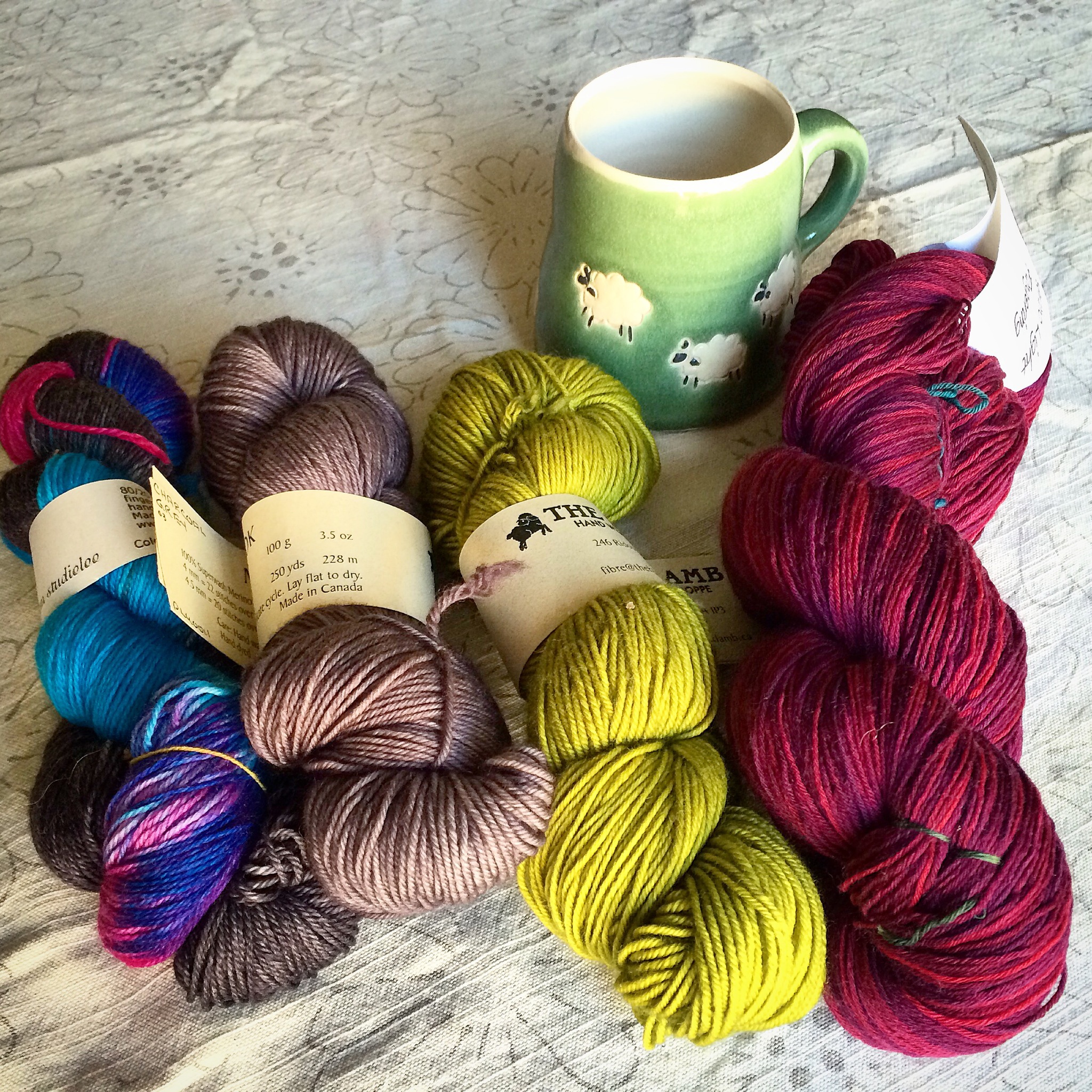 4 skeins of yarn and a hand-crafted mug